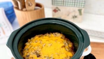 broccoli casserole cooked in crock with cheese melted on top.