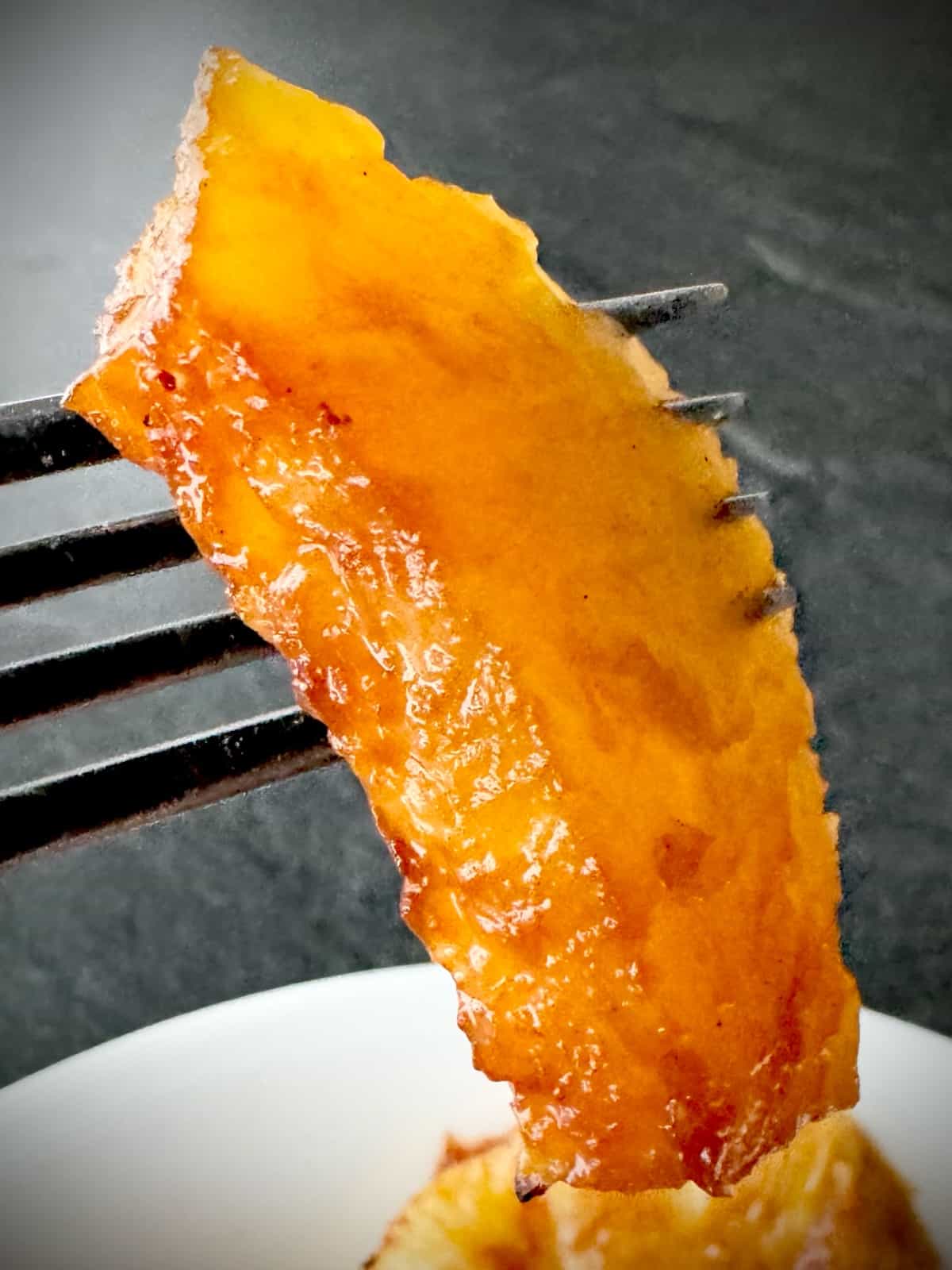 caramelized pineapple slice on a fork