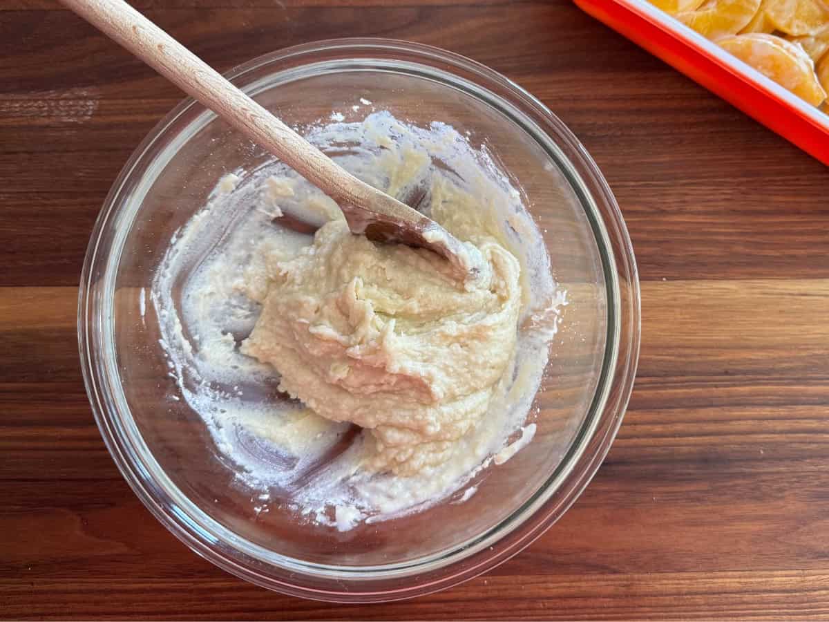 Mixing dough topping in bowl with wooden spoon.