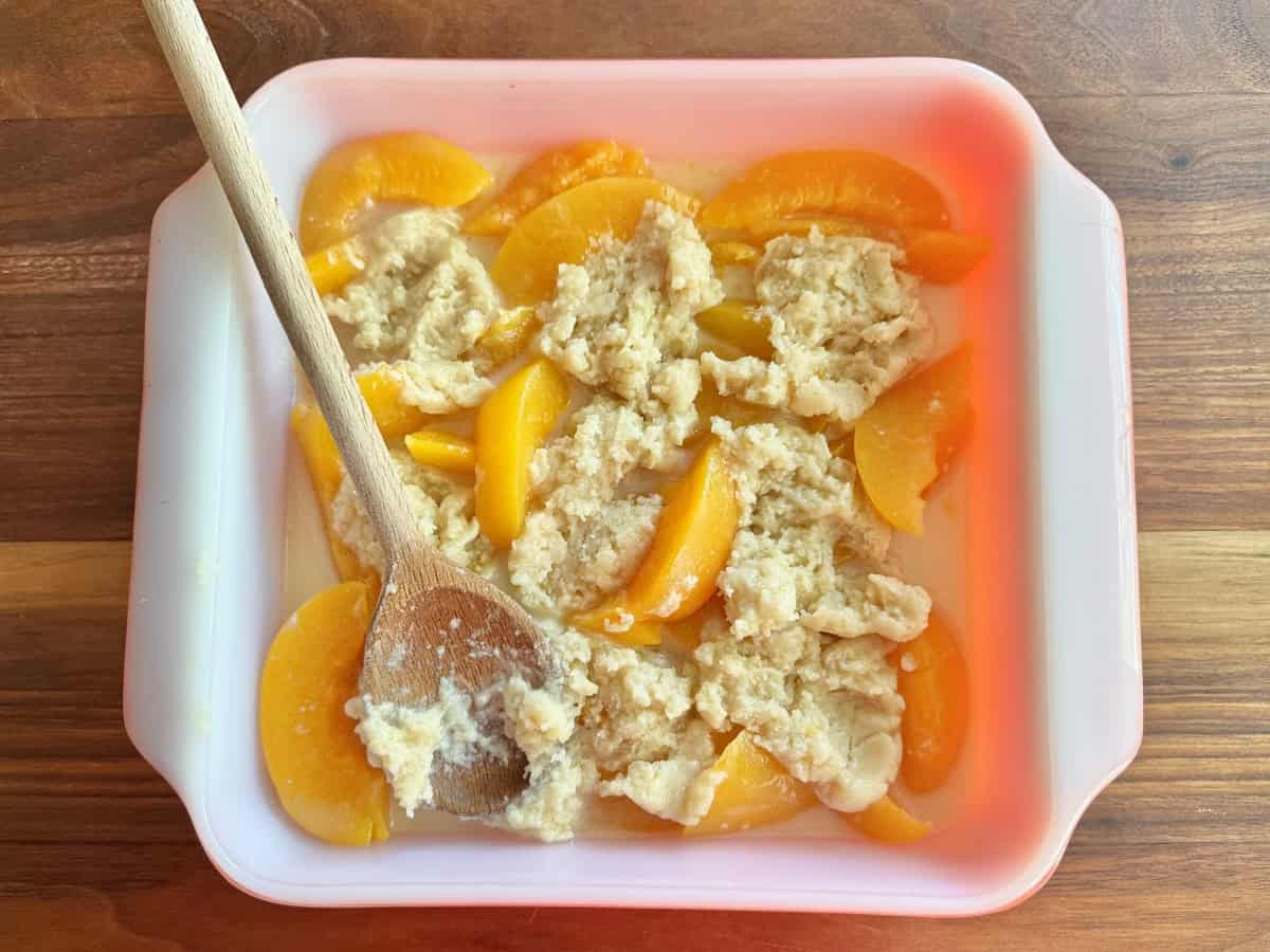 Raw dough spread over top of peaches.