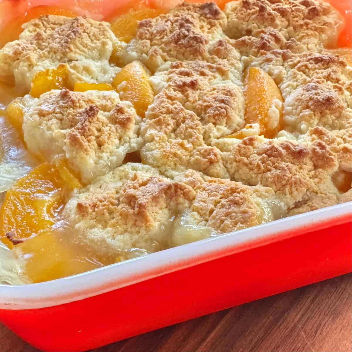 Peach cobbler in orange dish.