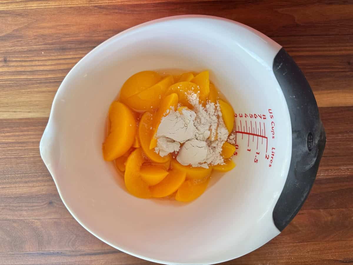 Peaches in bowl with some juice and Bisquick.