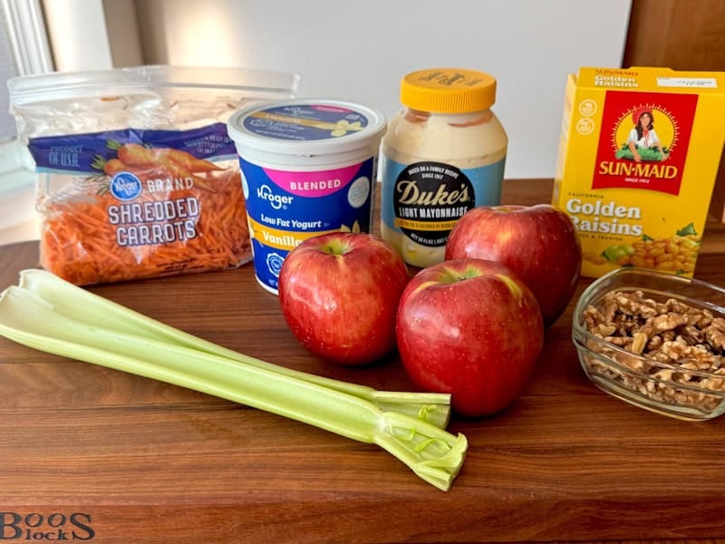 Ingredients for the apple carrot waldorf salad on a board.