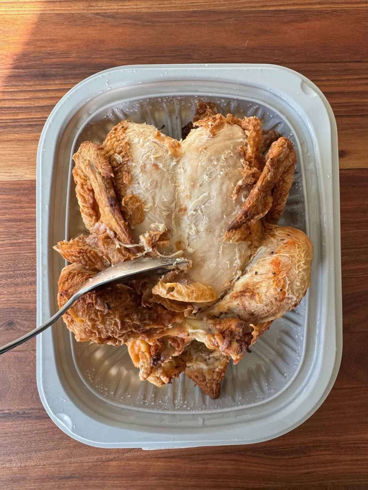 rotisserie chicken being peeled.
