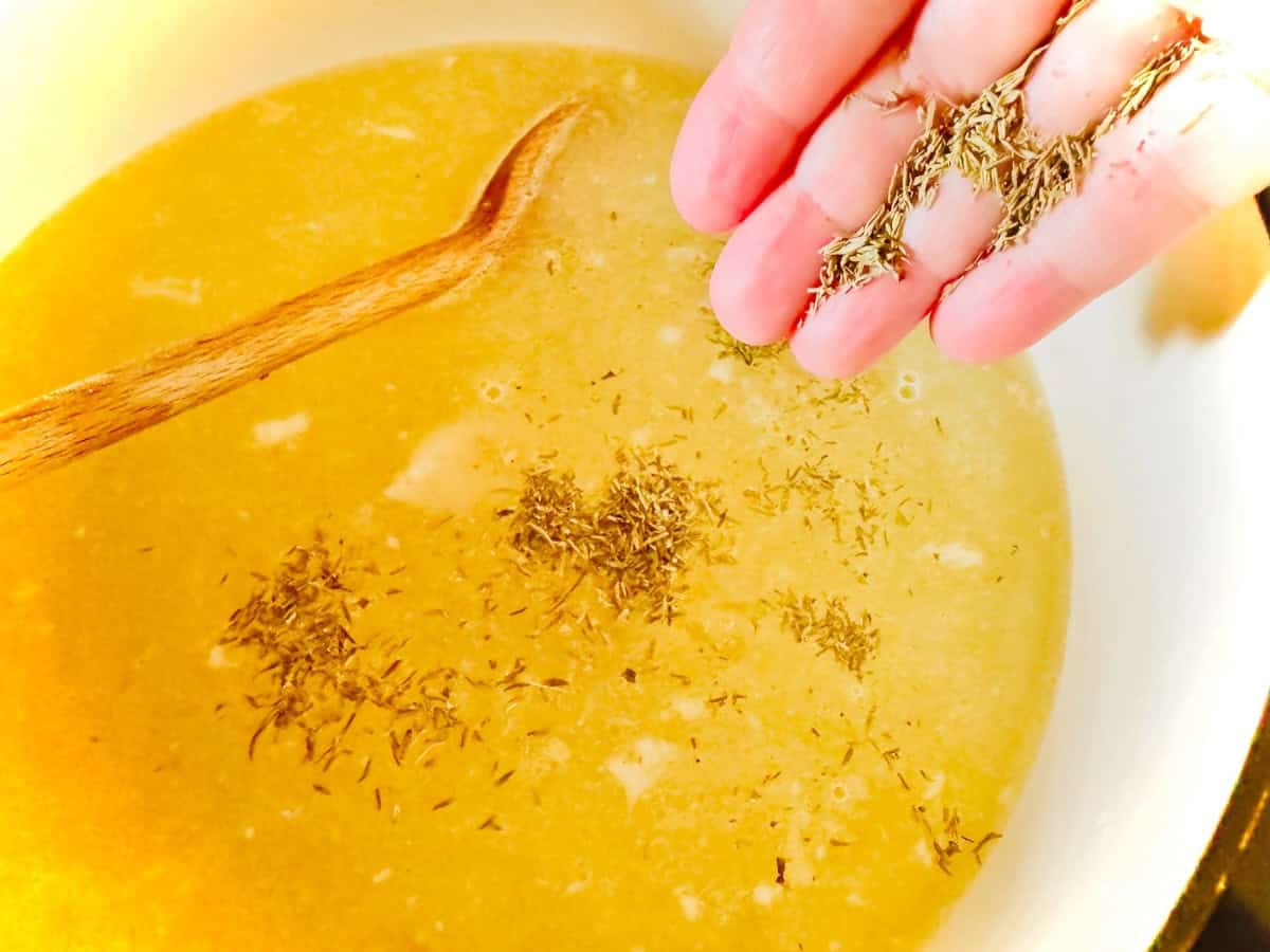 Thyme being added to broth.