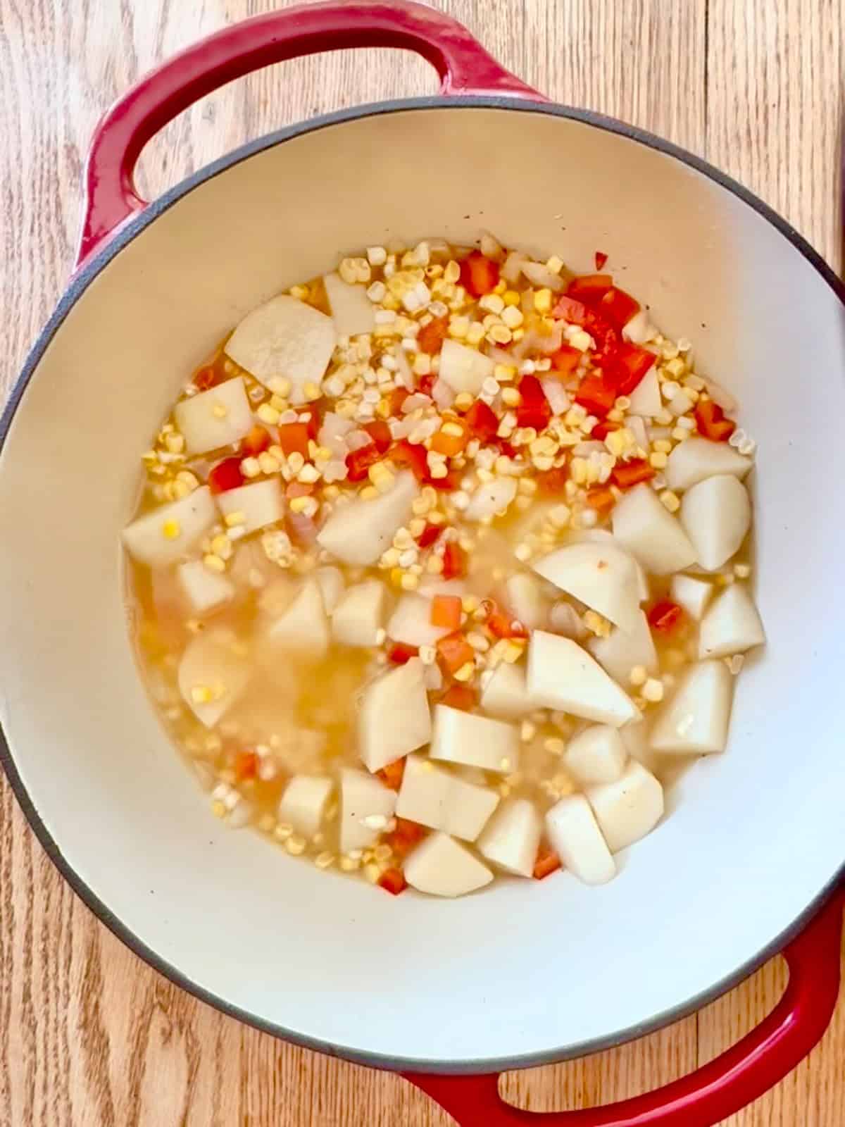 Pot of potatoes, corn, peppers cooking.