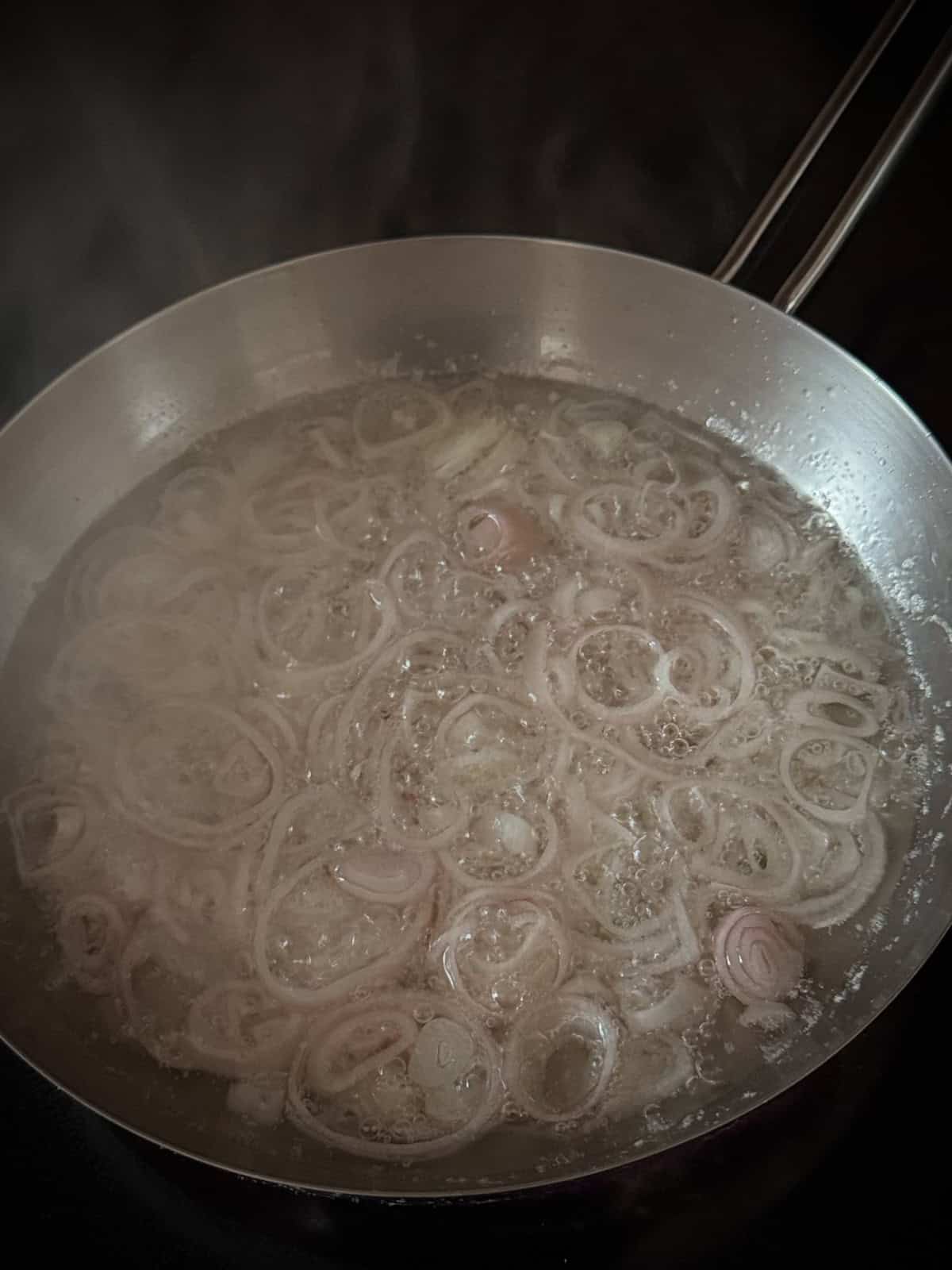 Frying shallots in vegetable oil.