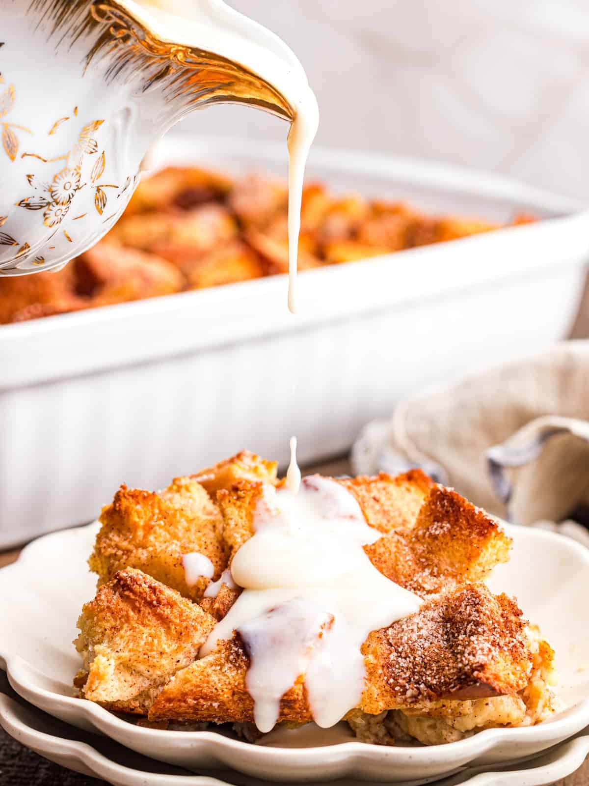 pouring vanilla sauce over baked pudding.